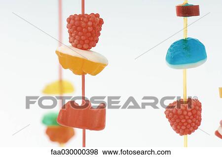 Stock Photo - Colorful candy hanging on strings, close-up. Fotosearch