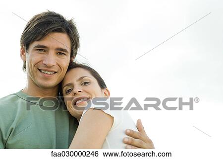 Couple embracing, smiling at camera View Large Photo Image Stock Photograph - Couple embracing, smiling at camera. Fotosearch