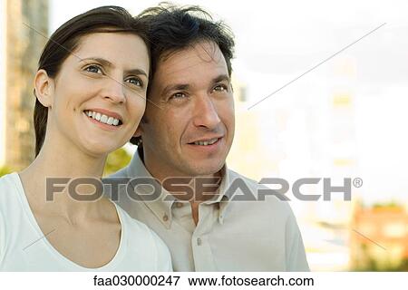 Stock Photo - Couple leaning against one another, smiling, looking up. Fotosearch