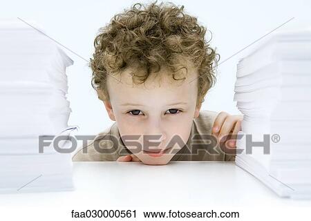 Curly haired boy peering between stacks of paper, smiling at camera View Large Photo Image Stock Image - Curly haired boy peering between stacks of paper, smiling at camera. Fotosearch
