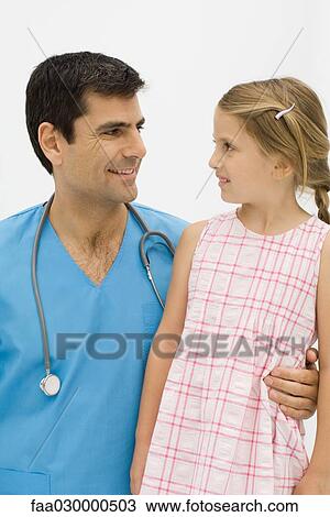 Doctor with arm around little girl's waist, both smiling at one another View Large Photo Image Stock Image - Doctor with arm around little girl's waist, both smiling at one another. Fotosearch