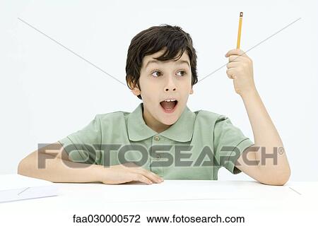 Stock Image - Excited boy holding up pencil, mouth wide open. Fotosearch