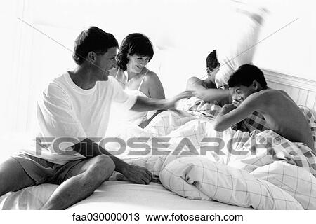 Family having pillow fight in bed, black and white View Large Photo Image Stock Image - Family having pillow fight in bed, black and white. Fotosearch