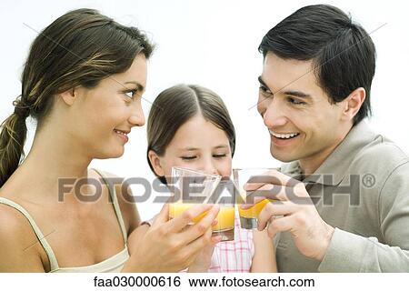 Family making a toast with orange juice, all smiling View Large Photo Image Stock Photograph - Family making a toast with orange juice, all smiling. Fotosearch