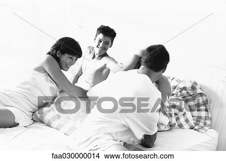 Family roughhousing in bed, black and white View Large Photo Image Picture - Family roughhousing in bed, black and white. Fotosearch