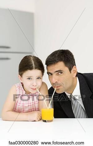 Father and daughter sharing glass of orange juice, drinking from straws, looking at camera View Large Photo Image Stock Image - Father and daughter sharing glass of orange juice, drinking from straws, looking at camera. Fotosearch