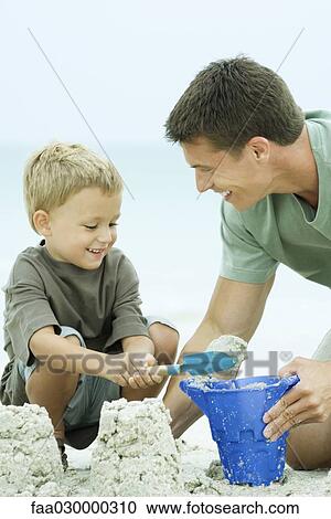 Father and son building sand castle together, smiling View Large Photo Image Stock Image - Father and son building sand castle together, smiling. Fotosearch