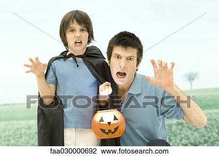 Father and son holding jack o'lantern, making scary faces at camera View Large Photo Image Stock Image - Father and son holding jack o'lantern, making scary faces at camera. Fotosearch