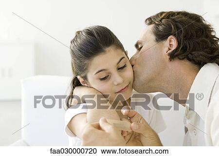 Father putting adhesive bandage on daughter's elbow, kissing her cheek View Large Photo Image Stock Image - Father putting adhesive bandage on daughter's elbow, kissing her cheek. Fotosearch