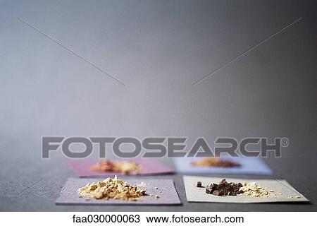 Four squares of paper holding different colored powders View Large Photo Image Stock Image - Four squares of paper holding different colored powders. Fotosearch