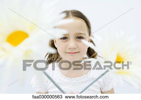 Girl behind flowers, smiling at camera, portrait View Large Photo Image Stock Image - Girl behind flowers, smiling at camera, portrait. Fotosearch