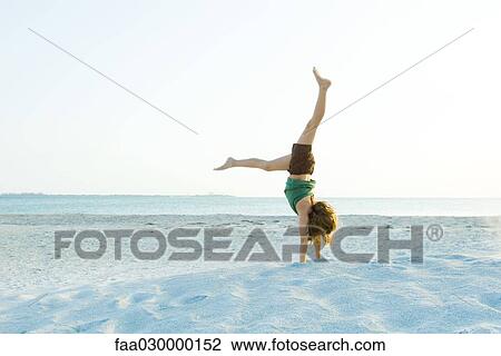 Girl doing handstand on beach View Large Photo Image Stock Image - Girl doing handstand on beach. Fotosearch