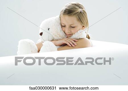 Girl holding teddy bear, smiling, looking down View Large Photo Image Stock Image - Girl holding teddy bear, smiling, looking down. Fotosearch