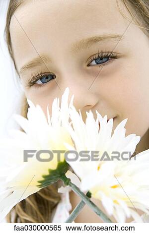 Girl smelling flowers, looking at camera, portrait View Large Photo Image Stock Photography - Girl smelling flowers, looking at camera, portrait. Fotosearch