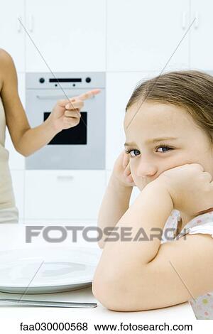Girl sulking at kitchen table, mother shaking finger, cropped view View Large Photo Image Stock Photo - Girl sulking at kitchen table, mother shaking finger, cropped view. Fotosearch
