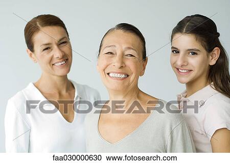 Stock Image - Grandmother, daughter, and preteen granddaughter, smiling at camera, portrait. Fotosearch