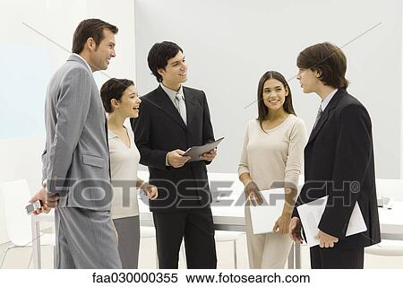 Group of business associates standing together, smiling, chatting View Large Photo Image Stock Photography - Group of business associates standing together, smiling, chatting. Fotosearch