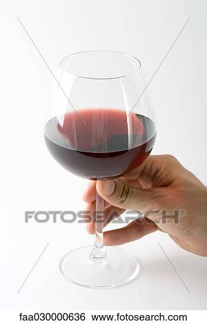 Hand holding glass of red wine, close-up View Large Photo Image Stock Photograph - Hand holding glass of red wine, close-up. Fotosearch