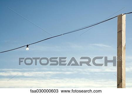 Lightbulb hanging from power line, wooden post View Large Photo Image Stock Image - Lightbulb hanging from power line, wooden post. Fotosearch