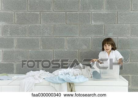 Little boy sitting in plastic storage container, laundry strewn beside him View Large Photo Image Stock Image - Little boy sitting in plastic storage container, laundry strewn beside him. Fotosearch
