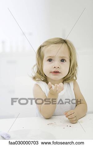 Little girl at table, holding bread in hand, looking up View Large Photo Image Stock Image - Little girl at table, holding bread in hand, looking up. Fotosearch