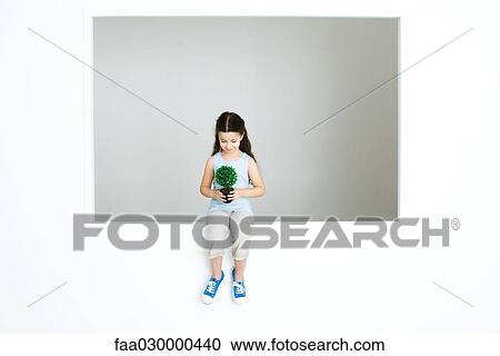 Little girl holding plant, full length View Large Photo Image Stock Image - Little girl holding plant, full length. Fotosearch