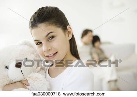 Little girl holding teddy bear, smiling at camera View Large Photo Image Stock Photo - Little girl holding teddy bear, smiling at camera. Fotosearch