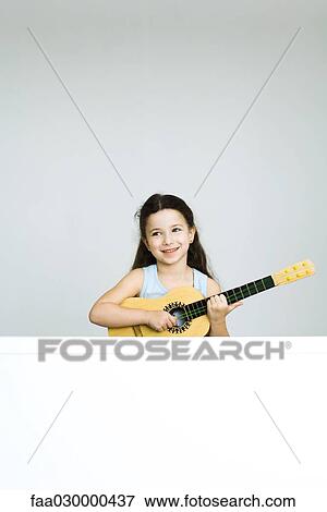 Little girl playing toy guitar, smiling View Large Photo Image Stock Photo - Little girl playing toy guitar, smiling. Fotosearch