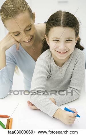Little girl sitting on mother's lap, coloring, smiling at camera View Large Photo Image Stock Photo - Little girl sitting on mother's lap, coloring, smiling at camera. Fotosearch