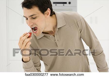 Man eating strawberry, mouth open View Large Photo Image Stock Photo - Man eating strawberry, mouth open. Fotosearch