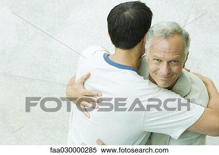 Man embracing adult son, smiling at camera, high angle view View Large Photo Image Stock Photography - Man embracing adult son, smiling at camera, high angle view. Fotosearch