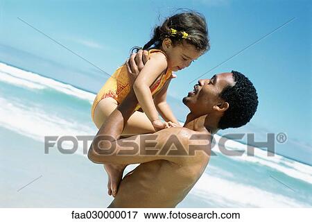 Man holding up daughter on beach, side view View Large Photo Image Stock Photo - Man holding up daughter on beach, side view. Fotosearch