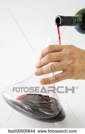 Man pouring red wine into decanter, cropped view of hand View Large Photo Image Picture - Man pouring red wine into decanter, cropped view of hand. Fotosearch