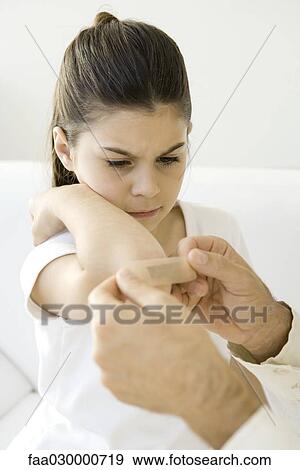 Man putting adhesive bandage on little girl's elbow, cropped view View Large Photo Image Stock Photo - Man putting adhesive bandage on little girl's elbow, cropped view. Fotosearch