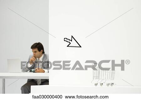 Man sitting in front of laptop computer, computer cursor and shopping cart in foreground View Large Photo Image Stock Image - Man sitting in front of laptop computer, computer cursor and shopping cart in foreground. Fotosearch