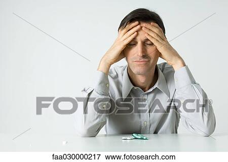 Man sitting next to pills, holding head, eyes closed View Large Photo Image Stock Photo - Man sitting next to pills, holding head, eyes closed. Fotosearch