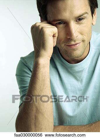 Man smiling, leaning on elbow, portrait View Large Photo Image Stock Photograph - Man smiling, leaning on elbow, portrait. Fotosearch