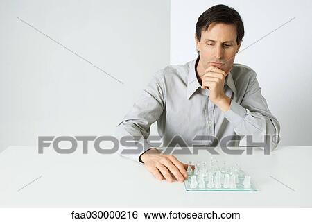 Man studying chess board View Large Photo Image Stock Photograph - Man studying chess board. Fotosearch