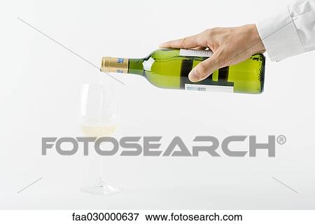Man's hand pouring white wine into glass, cropped view View Large Photo Image Stock Photo - Man's hand pouring white wine into glass, cropped view. Fotosearch