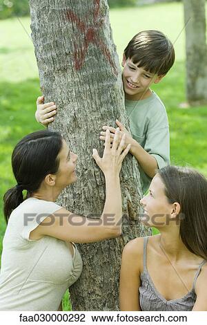 Mother and son embracing tree, teen daughter smiling over shoulder at them View Large Photo Image Stock Image - Mother and son embracing tree, teen daughter smiling over shoulder at them. Fotosearch