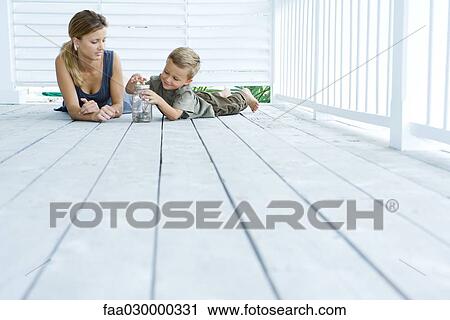 Mother and son lying on porch, looking at jar together View Large Photo Image Stock Image - Mother and son lying on porch, looking at jar together. Fotosearch