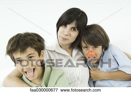 Stock Photo - Mother and two sons, boys sticking out their tongues, one wearing clown's nose. Fotosearch