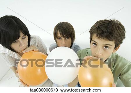 Mother and two sons inflating balloons, boys looking at camera View Large Photo Image Stock Image - Mother and two sons inflating balloons, boys looking at camera. Fotosearch