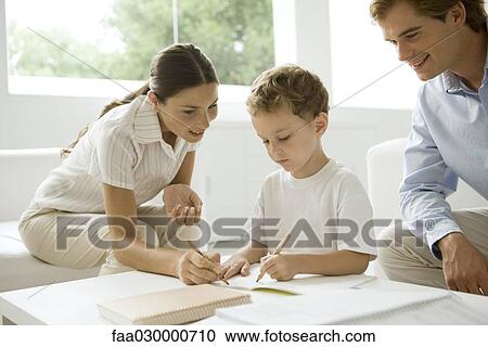 Parents helping little boy with his homework View Large Photo Image Stock Image - Parents helping little boy with his homework. Fotosearch