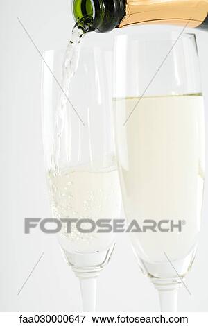 Pouring champagne into glasses, close-up View Large Photo Image Stock Photo - Pouring champagne into glasses, close-up. Fotosearch