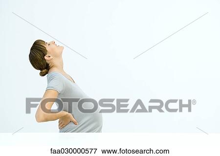 Pregnant woman holding back, leaning back, gritting teeth View Large Photo Image Stock Photo - Pregnant woman holding back, leaning back, gritting teeth. Fotosearch