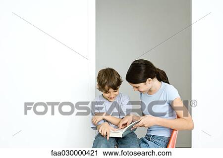 Preteen girl and little brother reading book together View Large Photo Image Stock Image - Preteen girl and little brother reading book together. Fotosearch