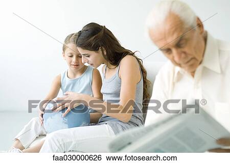Preteen girl and younger sister looking at globe together, senior man reading newspaper in foreground View Large Photo Image Stock Photograph - Preteen girl and younger sister looking at globe together, senior man reading newspaper in foreground. Fotosearch