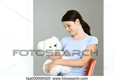 Stock Image - Preteen girl holding teddy bear. Fotosearch