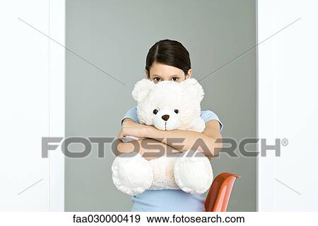Preteen girl hugging large teddy bear, peeking at camera View Large Photo Image Stock Photo - Preteen girl hugging large teddy bear, peeking at camera. Fotosearch